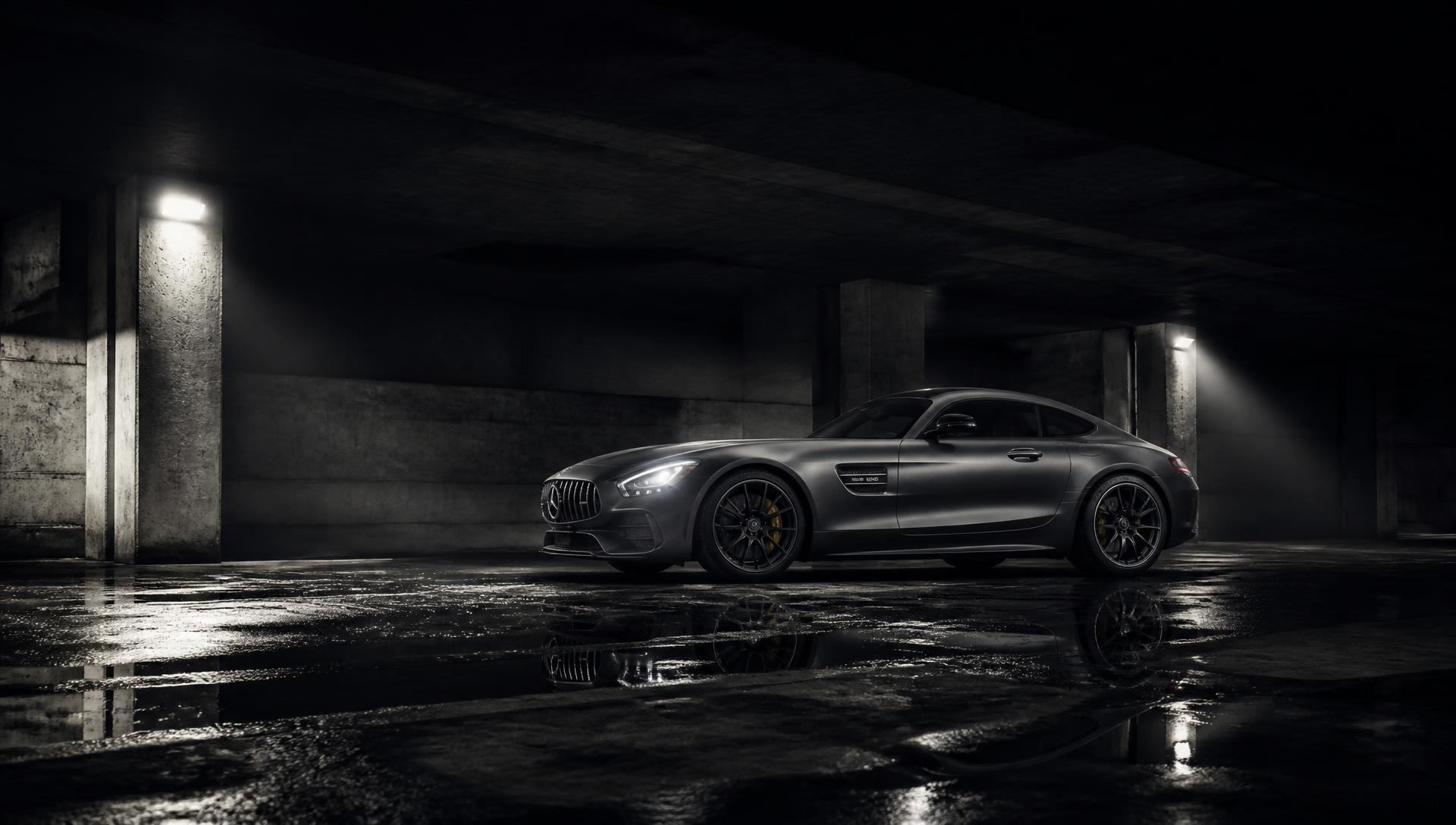 Luxury performance coupé lit dramatically in a dark concrete space